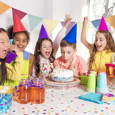 Colorful kids birthday party with balloons, birthday cake, decorations, and children enjoying activities